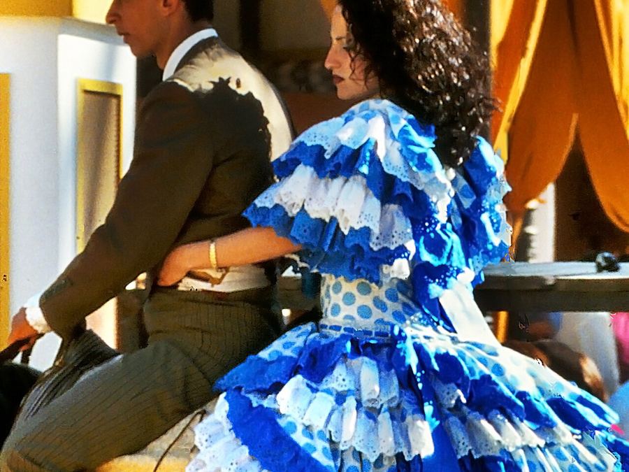 Pareja a caballo con traje de gitana en la Feria del Caballo