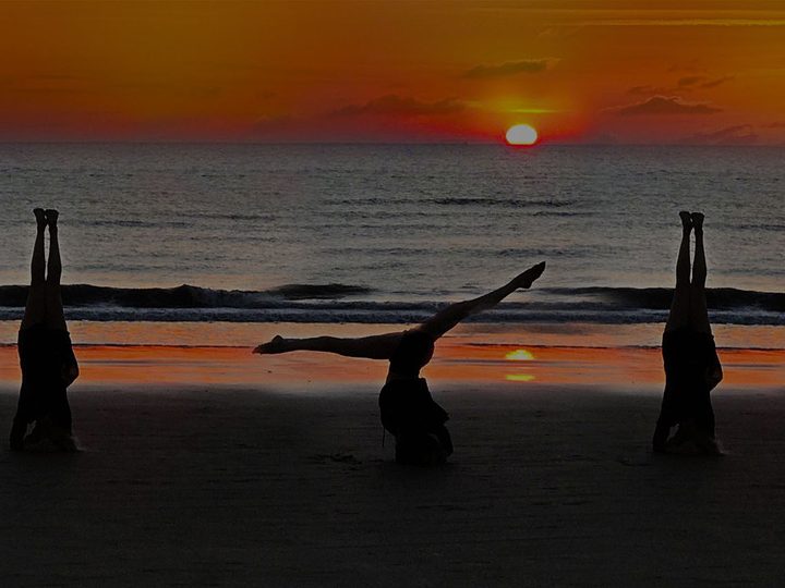 Poses inversées sur la plage au coucher du soleil