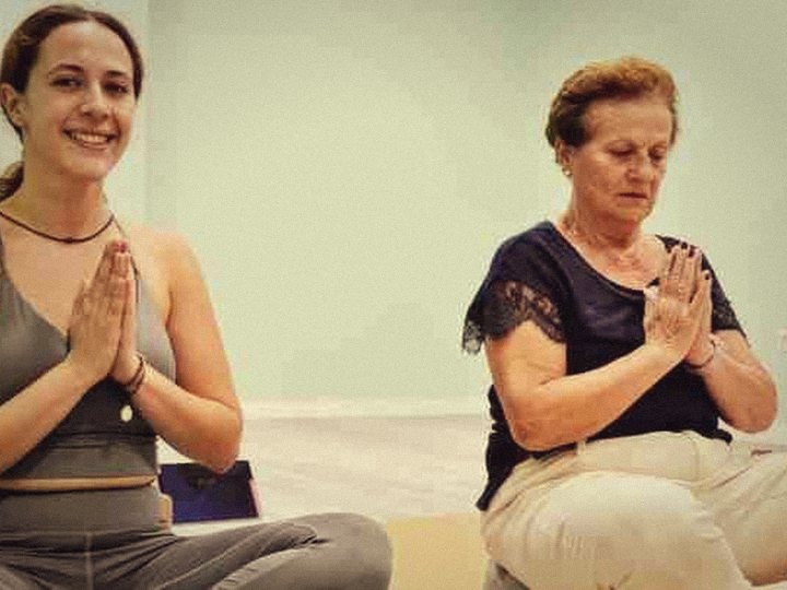 Due studentesse sorridono con le mani giunte alla fine della lezione