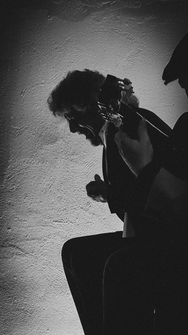 Guitarrista tocando en una sala en penumbra en Jerez